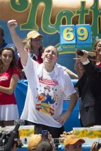 Joey Chestnut, center, wins the Nathan's Famous Fourth of July International Hot Dog Eating contest with a total of 69 hot dogs and buns at Coney Island, Thursday, July 4, 2013, in the Brooklyn borough of New York. (AP Photo/John Minchillo)