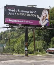 A billboard that a Toronto company says is meant to connect female college students with "sugar daddies" who pay a fee to join its website service is seen on Wednesday, July 10, 2013, in Pittsburgh. Pennsylvania State police Cpl. Raymond Schafer, who works for a western Pennsylvania vice squad, confirmed the ads are legal because, as Perkins contends, they don't include a direct offer of money for sex. (AP Photo/Keith Srakocic) 