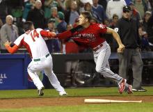 Canada's Jay Johnson, right, and Mexico's Eduardo Arredondo, left, fight during the ninth inning of a World Baseball Classic game on Saturday in Phoenix. (AP Photo/Matt York)