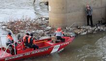 A man who jumped from the Interstate 80 river bridge Friday waits for a rescue crew to reach him. (Press Enterprise/Jimmy May)