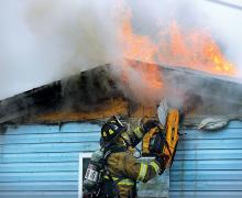 A firefighter uses a saw to open the wall and expose the flames at this home on Tower Driver in Montour Township Friday morning. (Press Enterprise/Keith Haupt)