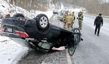 A Honda Civic came to rest on its roof after leaving the roadway along Numidia Drive outside Catawissa Wednesday morning. Dala Lambert, Lancaster lost control of her car after sliding on ice in the roadway. (Press Enterprise/Keith Haupt)