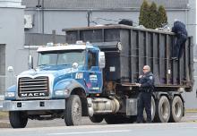 Bloomsburg Police officers Jim Cromley, bottom, and Shawn Hill examine the trucks load of scrap after it was involved in the tearing down of several Service Electric Cable lines align Old Berwick Road in Scott Township Monday morning. The truck was stopped on the East Bloomsburg Bridge. (Press Enterprise/Keith Haupt)