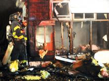 Keith Haupt/Press Enterprise Firefighters peel back the siding as they search for hot spots after dousing a blaze at a vacant Nescopeck home early Thursday.