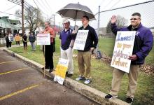 Striking Danville High School teachers picket at the corner of East Market and Wall streets in Danville as the rain begins on Tuesday morning. (Press Enerprise/Bill Hughes)