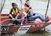 Cody Miller and Nicole Alden ride on the Bloomsburg Fire Department's water rescue boat to shore. (Press Enterprise/Bill Hughes)