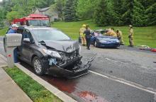 Fluid leaks out of a Toyota Sienna as crews from Espy and Lightstreet attempt to remove two passengers from a Chevrolet Monte Carlo SS following a motor vehicle accident in front of 2212 Bentley Drive in Bloomsburg on Saturday afternoon. (Press Enterprise/Mary Bove) 