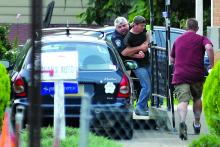 South Centre Township Police Chief Bill Richendrfer tackles Wayne Shiffer as Shiffer tries to go into his home after a two-hour police standoff on the Mifflinville Bridge Monday morning. Shiffer, 47, was first spotted sitting on the ledge of the bridge around 4:17 a.m. He was suicidal, police say.