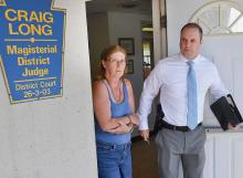 Linda Tarlecki is led from District Judge Crain Long’s office by Trooper Francis McDonald following her arraignment Friday in Catawissa.