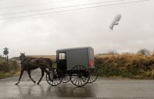 An unmanned Army surveillance blimp, which broke loose from its tether in Maryland, floats through the air about 1,000 feet from the ground while dragging a several-thousand foot tether line south of Millville Wednesday afternoon. (Press Enterprise/Jimmy May)