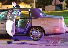 Officer Randy Gaugler looks over evidence outside a car involved in Tuesday night's shooting. (Press Enterprise/Jimmy May)