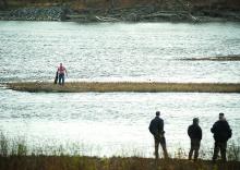 Officers watch fugitive Stephen Whitenight as he waits for rescue after running into the Susquehanna to escape authorities. 