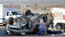 Emergency crews work to free a passenger from the front seat who is confined in an upside-down SUV, which flipped while towing a trailer west on Interstate 80 just east of the Mifflinville exit Thursday afternoon. (Press Enterprise/Jimmy May)