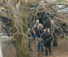 SWAT members speak with a handcuffed John Karns after a standoff at his home at 25 Valley Road. (Special to the Press Enterprise/Jessica Morgan)