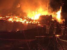 Susan Schwartz/Press Enterprise Firefighters gather near a burning house as they wait for water to be pumped to the scene early Thursday morning.