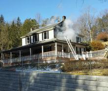 Smoke pours from a window at 12 Long Woods Drive. (Press Enterprise/Julye Wemple)