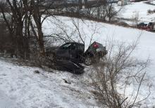A mangled pickup truck sits at the bottom of the embankment it tumbled down after going off Route 254 near the Montour-Delong Fairgrounds on Monday. (Press Enterprise/Chris Krepich)