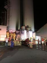 Firefighters check for hot spots after dousing a blaze in the silo control room at Autoneum.
