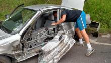 Avery Eddy, 18, Hughesville, reaches inside his mangled car retrieving personal belongings following crash near HRI, Inc. Eddy sustained only minor cuts.(Press Enterprise/Leon Bogdan)