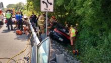 Rescuers work to remove a Shamokin couple from a Dodge Dart that crashed into a small culvert off Route 11 across from Steve Shannon Tire in Mahoning Township Thursday morning. Police said the man and woman each suffered head injuries and were taken to Geisinger Medical Center. (Press Enterprise/Leon Bogdan)