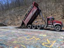 A dump truck spills a load of soil on Graffiti Highway near Centralia, which is being covered over. (Press Enterprise/Jimmy May)