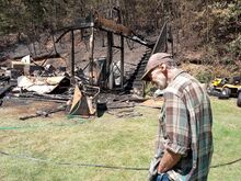 Joe Bucanelli Jr., 73, assesses losses to his large two-story garage and shed in overnight fire Sunday in Bear Gap near Elysburg. (Press Enterprise/Leon Bogdan)