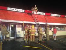Firefighters check the roof of May's Drive In in Montour Township late Saturday.
