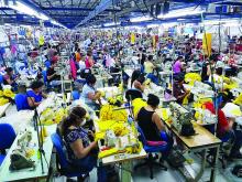 In this photo provided by Milco, workers assemble clothing inside an El Salvador factory.