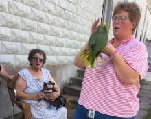 Waunita Young, 79, holds her dog while her daughter, Billie Jo Scott, 42, comforts the family's parrot after the animals were rescued from their burning home.