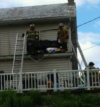 Firefighters toss a damaged couch from the second floor of 59 Jackson Road, Cleveland Township after fighting a fire there. (Press Enterprise/Julye Wemple)