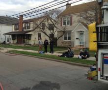 People detained by police at an active meth lab in 719 E. Second St., the house to the left of the photo, are watched over by police on Friday morning. (Press Enterprise/Peter Kendron)