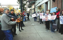 Protestors sing songs outside the Greenly Center along Main Street in Bloomsburg Friday morning. The protestors were on hand as U.S. Congressman Lou Barletta attended a meeting.