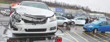 A Chevrolet Cruze sits atop a flatbed tow truck after its driver lost control of the car and drove into a box truck after hitting the blue vehicle right, and silver car, center, Monday morning outside Walmart in Buckhorn. (Press Enterprise/Keith Haupt)