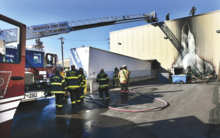 Press Enterprise/Bill Hughes Firefighters soak down an exterior area at the Wise Foods plant in Berwick after fire in a pile of debris damaged and scorched the side of the building on Sunday evening.