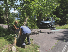 Press Enterprise/Jimmy May Tow truck operators cut down the remains of tree to remove a Honda CRV. The SUV driver was found dead after the vehicle struck the tree in front of 242 River Road in Nescopeck Township Friday morning.