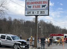 Firefighters work to clean up debris after a serious crash by the Bloomsburg Fair offices Saturday.