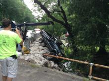 A crew from West End Towing lifts a Ford F-150 from the stream it plunged into Wednesday afternoon. (Peter Kendron/Press Enterprise)