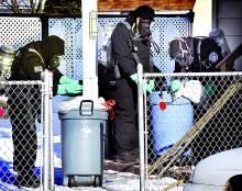 Agents from the state Attorney General’s office go through the trash at 405 East Sixth Street in Berwick during a raid on the suspected meth house on Thursday morning. 