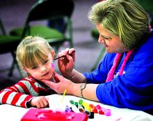 Carissa Longfoot, 4, gets her face painted by Sue Stout