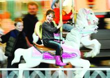 Lola Saunders, 6, Philadelphia is all smiles as she rides the carousel at the Farm Show in Harrisburg Monday