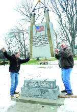 Carl Singley II, left and John Barratt, from Catawissa Monument prepare to place the top stone to the American Revolution War Memorial in Memorial Park in Danville