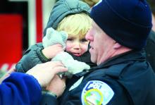 Sgt. Roger Van Loan holds the grandson of Judy Helwig after an accident