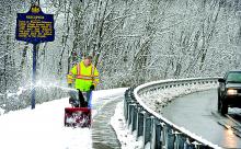 Nescopeck borough worker Dave Whitmire clears the Third Street sidewalk that leads to the Berwick-Nescopeck bridge's walkway over the Susquehanna River on Wednesday. 