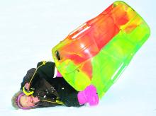 Kiyla Rogers, 4, and Aydin Kipple, riding behind her, roll in their plastic toboggan as the pair from Danville sled