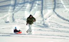 Roth Reason, Danville, pulls his daughter Nadia Reason, 4, on her sled through the snow on the grounds of Danville State Hospital Friday morning. "The kids think it's too cold to sled," the father said after pulling her to the car.