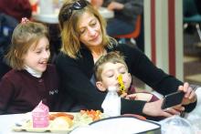 Holy Family School's River Seward, left, and John Seward, right, pose for a photograph with their aunt Maria Dorshefski just before eating lunch together.