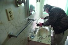 Press Enterprise/Jimmy May Jim Stair lifts the cover on the back of a toilet in a vacant apartment to make sure there is no water sitting in it Wednesday in Bloomsburg. The sewer authority is telling him he needs to pay the $30 a month fee or block the sewer line off with concrete. 
