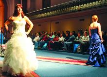 Candice Buttorf stands to show off a wedding gown at the Press Enterprise Bridal Fair