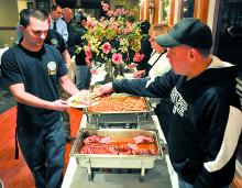 Bloomsburg firefighter Todd Barton is served ham by Bloomsburg Police Chief Leo Sokoloski 