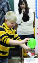 Nescopeck Elementary student Dustin Peters demonstrates how gas that's produced while mixing baking soda and vinegar can inflate a balloon
